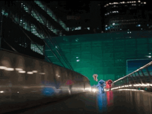 a woman in a red dress is standing in front of a green building at night