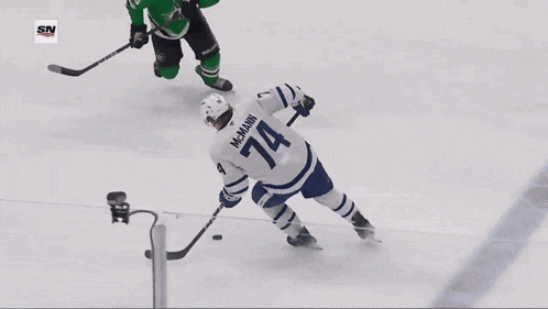 a hockey goalie blocks a shot in front of an ad for baylorscott & white