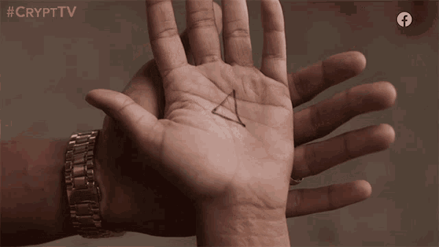 a hand with a triangle drawn on it and the words #crypttv behind it