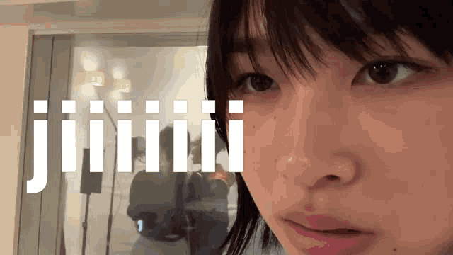 a close up of a woman 's face with the word jiiii visible