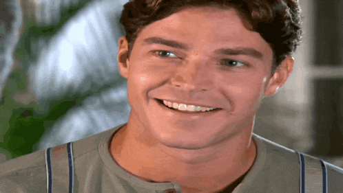 a close up of a man 's face smiling with his teeth showing