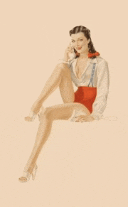 a woman in a white shirt and red shorts is sitting on the floor talking on a phone