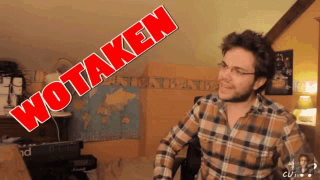 a man in a plaid shirt stands in front of a sign that says " wotaken "