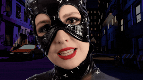 a woman in a catwoman costume has a kiss bubble above her head
