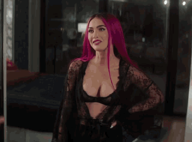 a woman with pink hair is holding a man 's hand and smiling