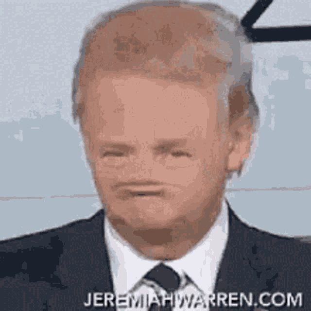 a man in a suit and tie is making a face .
