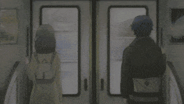 a man and a woman are standing next to each other on a subway train
