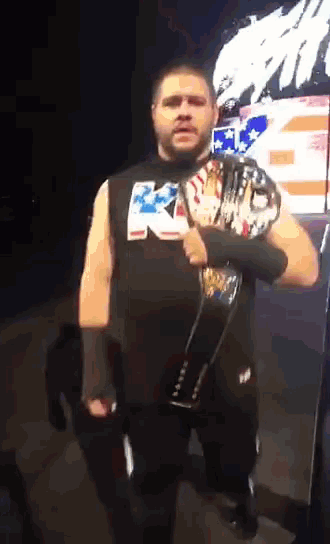 a wrestler holding a belt that says rkc on it