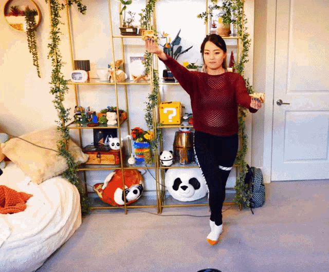 a woman in a red sweater is standing in front of a shelf with stuffed animals