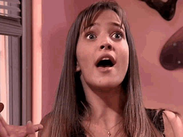 a woman is making a surprised face with her mouth open .