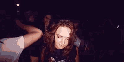 a woman is covering her face with her hand while a man holds her hand .