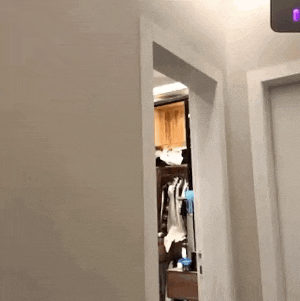 a person is walking through a closet with clothes hanging on the wall .