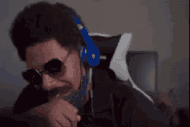 a man wearing headphones and sunglasses is looking at the camera