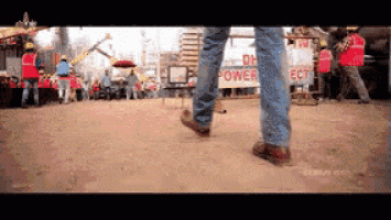 a person walking in front of a dh power sign