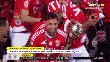 a soccer player is holding a trophy in front of a crowd