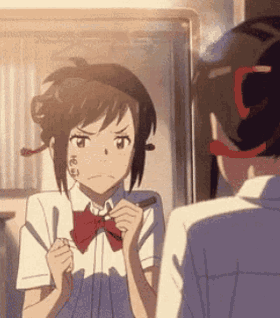 a girl in a school uniform is holding a knife and fork in her hand .