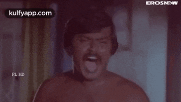 a man without a shirt is sticking his tongue out .