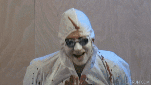 a gif from gifrun.com shows a person with blood on their face standing next to a dead body