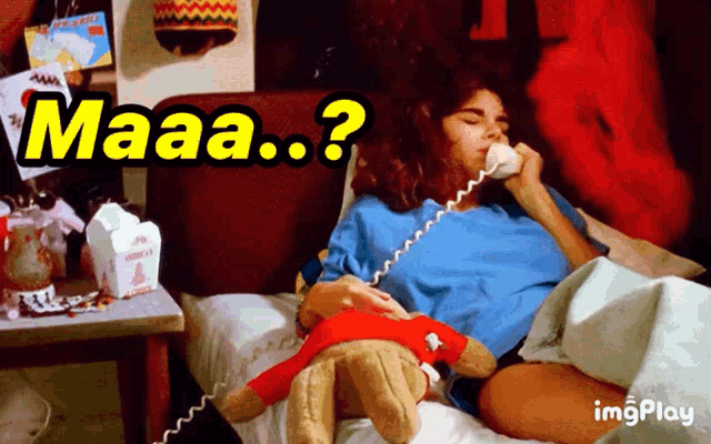 a woman laying in bed with a teddy bear talking on a phone with the words maaa ? behind her