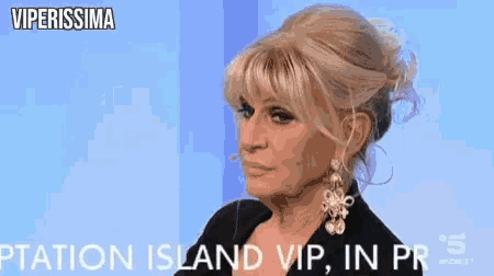a woman wearing earrings and a black jacket says viperissima on the screen