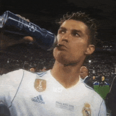 a man is drinking from a can that says champions league