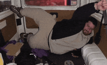 a man laying on his back in a van with a sticker on the door that says ' ambulance ' on it