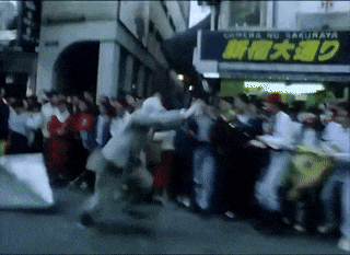 a crowd of people are gathered in front of a sign that says sakurai