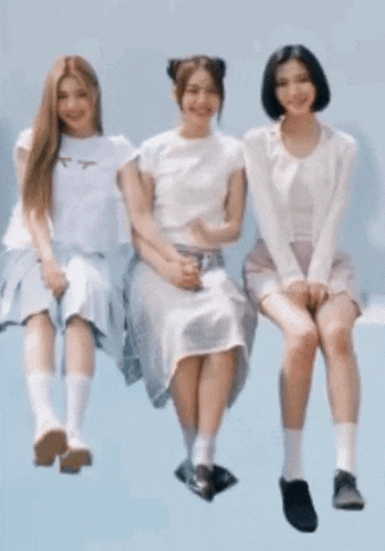 three women are sitting next to each other on a blue background