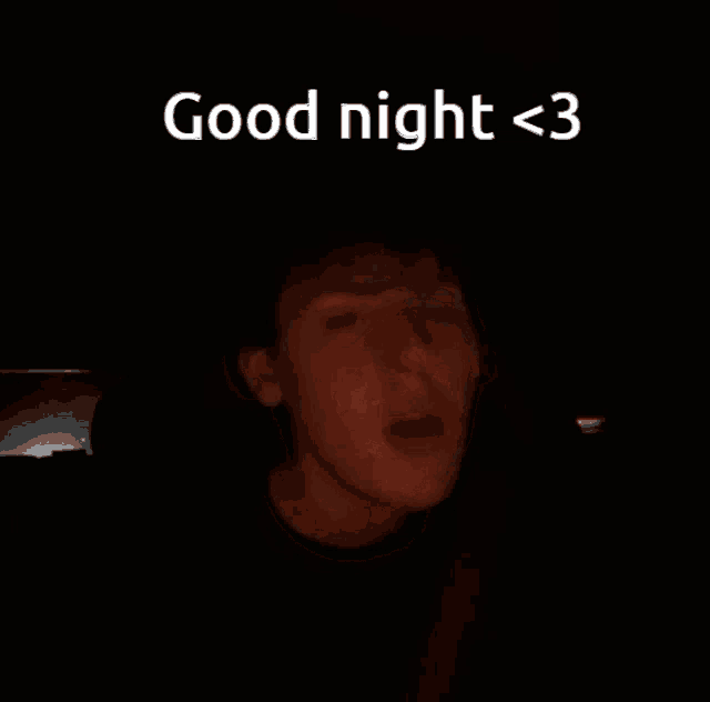 a man is sitting in a car in the dark with the words `` good night < 3 '' written on the screen .