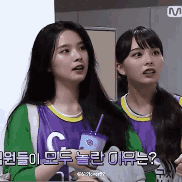 two girls are standing next to each other and one of them is wearing a purple shirt with the letter c on it