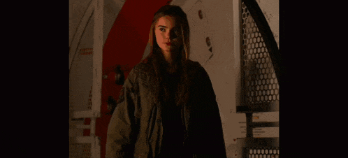 a woman is standing in a dark room with the words who 's being unreasonable behind her
