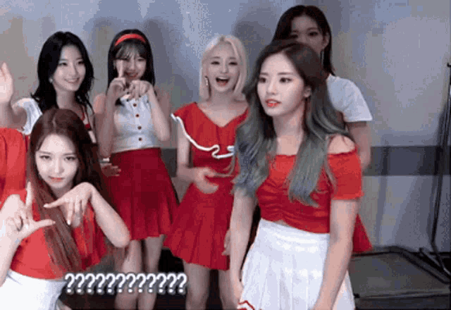 a group of girls are posing for a picture and one of them is wearing a red skirt