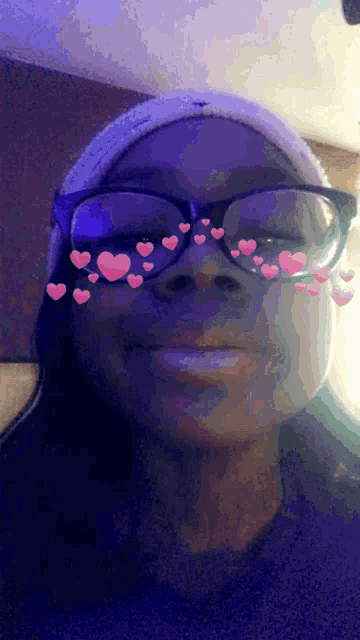 a woman wearing glasses and a white hat with pink hearts on them