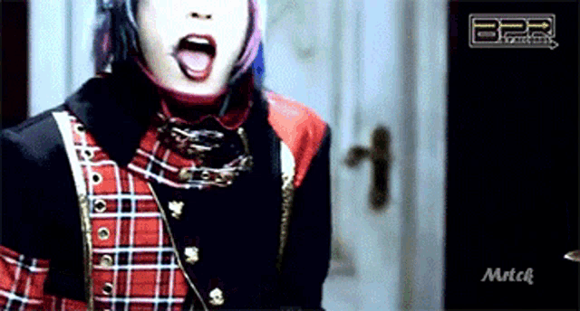 a woman in a plaid shirt and black jacket is screaming in front of a bpr logo