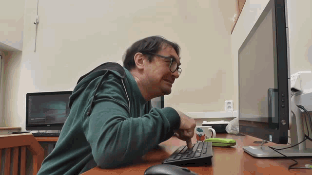 a man sitting at a desk with a keyboard and mouse