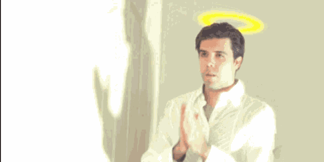a man with a halo on his head prays with his hands folded