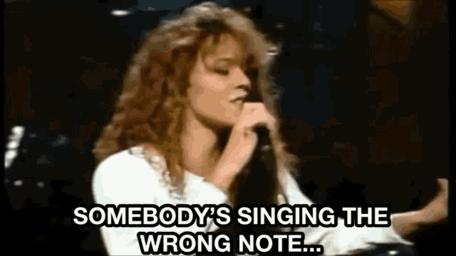 a woman singing into a microphone with the words somebody 's singing the wrong note written below her