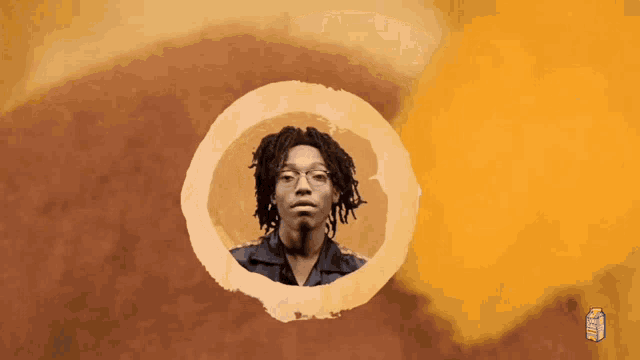 a picture of a man with dreadlocks and glasses in a circle