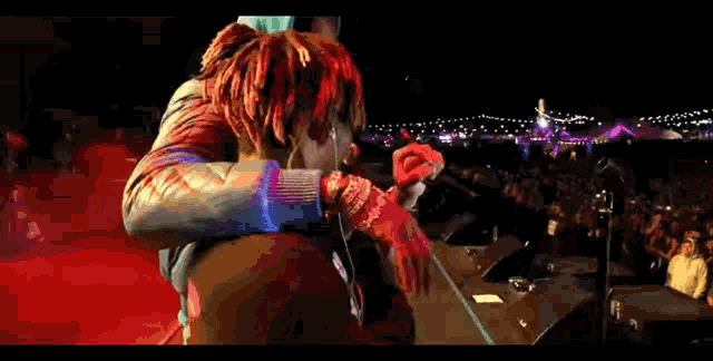a man taking a picture of a man with dreadlocks on a stage .
