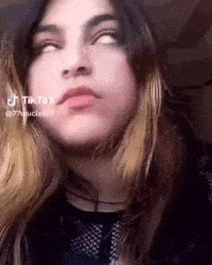 a close up of a girl 's face with her eyes closed and a tiktok watermark on her face .