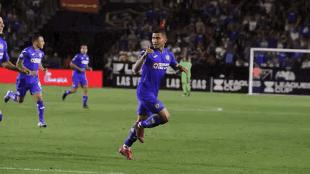 a soccer player in a blue uniform is running on the field .