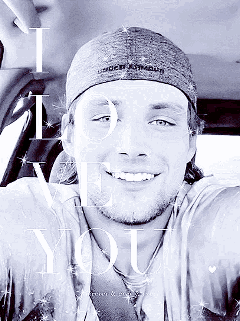a man wearing an under armour hat is smiling in a black and white photo
