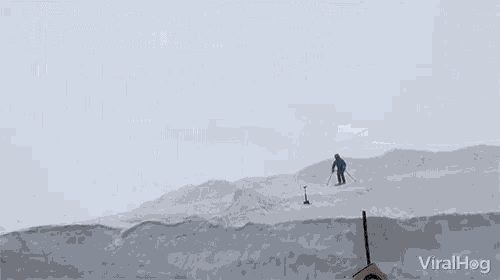 a man is skiing down a snow covered road