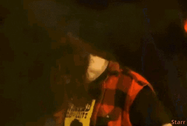 a man in a plaid shirt with a wanted poster on it