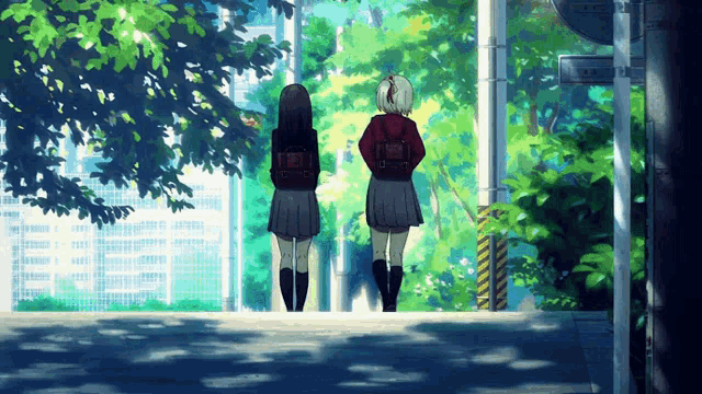 two girls are standing next to each other on a sidewalk with trees in the background and a sign that says ' a '