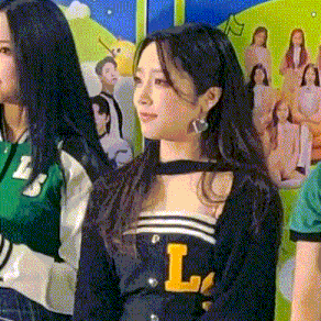 a woman wearing a choker and earrings is standing next to another woman .
