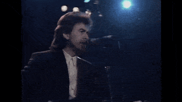 a man singing into a microphone on a stage .