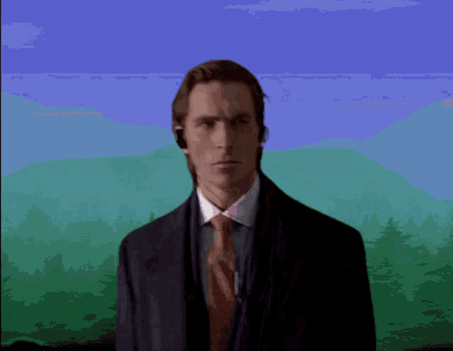 a man in a suit and tie is standing in front of a mountain