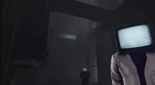 a person with a tv on their head standing in a dark room