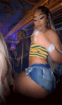 a woman in a striped top and shorts is dancing in a room .